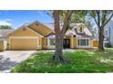 Inviting single Gathering home featuring a two-car garage, mature trees, and well-maintained lawn at 10206 Evening Trail Dr, Riverview, FL 33569