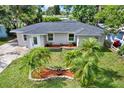 Inviting home exterior showcasing mature landscaping and a well-maintained lawn with decorative palm trees at 10375 106Th Ter, Largo, FL 33773