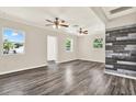 Bright living room featuring gray wood floors, ceiling fans and views to the exterior at 10375 106Th Ter, Largo, FL 33773