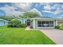 Charming single-story home with well-manicured lawn, brick driveway, and a screened-in two car garage at 10728 Moshie Ln, San Antonio, FL 33576