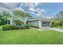 Charming single-story home with well-manicured lawn, brick driveway, and a screened-in two car garage at 10728 Moshie Ln, San Antonio, FL 33576