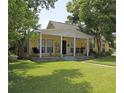 Quaint yellow home with a covered porch, swing, well maintained lawn, and mature shade trees at 13637 13Th St, Dade City, FL 33525