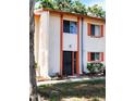 Exterior view of townhouse featuring stucco walls, coral trim, and decorative shutters at 1620 58Th N Ave # 6, St Petersburg, FL 33712