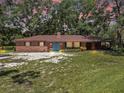 Charming single-story brick home with a well-maintained lawn and colorful flowerbeds at 1753 Ranchette Rd, Wesley Chapel, FL 33543