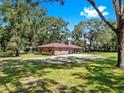 Beautiful single-story home with lush green lawns shaded by mature trees at 1753 Ranchette Rd, Wesley Chapel, FL 33543