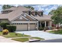 Stunning single-Gathering home featuring a three-car garage, dormer windows, and well-maintained landscaping at 22925 Collridge Dr, Land O Lakes, FL 34639