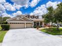 Beautiful one-story home showcases a three-car garage, well-kept lawn, and inviting front porch at 22925 Collridge Dr, Land O Lakes, FL 34639