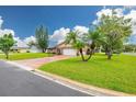 Well-maintained single-story brick home featuring a lush green lawn, mature trees, and a paved driveway at 314 Circle Dr, Palm Harbor, FL 34683