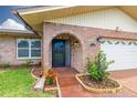 Close-up of the brick-arched front door with a well-kept garden bed and manicured lawn at 314 Circle Dr, Palm Harbor, FL 34683
