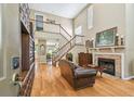 Elegant living room with hardwood floors, a cozy fireplace, and a staircase leading to the second floor at 3304 W Harbor View Ave, Tampa, FL 33611