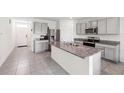 Spacious kitchen with granite countertops, stainless steel appliances, gray cabinets, and tile flooring at 33657 Field Maple Loop, Wesley Chapel, FL 33545