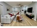 Bright living room with wood floors, white sofa, modern ceiling fan, and large windows at 4029 9Th S Ave, St Petersburg, FL 33711
