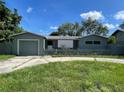 Charming single-story home with fenced front yard, driveway, and attached garage under a blue sky at 4591 54Th N Ave, St Petersburg, FL 33714