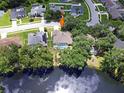 Aerial view of a home with a screened pool, surrounded by mature trees, and backing onto a serene lake at 4617 Basswood St, Land O Lakes, FL 34639