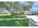 Inviting single-story home features a well-maintained lawn and an attached garage at 4712 Coachmen Rd, New Port Richey, FL 34655