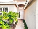 Inviting front entrance with lush landscaping and brick walkway leading to the front door at 4950 Sandy Brook Cir, Wimauma, FL 33598