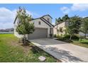 Two-story home featuring a spacious garage and well-maintained landscaping and lawn at 6347 Ten Acre Ct, Zephyrhills, FL 33541
