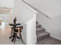 Hallway featuring a staircase, tiled floors, and an elegant decorative table at 6347 Ten Acre Ct, Zephyrhills, FL 33541