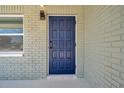 Close up of the modern navy blue front door, with painted brick, and sidelight window at 6352 Canton S St, St Petersburg, FL 33712