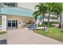 Well-maintained Sunrise Two building entrance, featuring lush landscaping, shade, and covered entry at 7979 Sailboat Key S Blvd # 505, South Pasadena, FL 33707