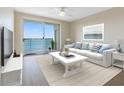 Bright living room with stylish decor and stunning water views from the sliding glass doors to the balcony at 7979 Sailboat Key S Blvd # 505, South Pasadena, FL 33707