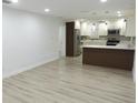 Spacious living area leading into the kitchen featuring gorgeous new flooring at 814 W 131St Ave, Tampa, FL 33612