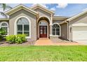 Charming single-story home with a well-manicured lawn, lush landscaping, and a two-car garage at 9126 Cypress Keep Ln, Odessa, FL 33556