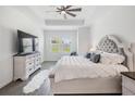 Elegant main bedroom featuring a tray ceiling, plush bed, and a large TV for ultimate comfort at 10278 Otter Sky Ct, San Antonio, FL 33576