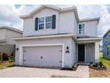 Stunning two-story home with a gray exterior, two-car garage, and a beautifully landscaped yard at 12215 Blue Pacific Dr, Riverview, FL 33579