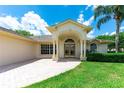 Welcoming facade with an arched portico, columns and a well-manicured lawn at 14096 Pullman Dr, Spring Hill, FL 34609