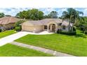 Spacious lawn with driveway leading to a two-car garage and front entrance at 14096 Pullman Dr, Spring Hill, FL 34609