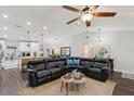 Spacious living room with large leather sectional, ceiling fan, and hardwood flooring at 1513 Loretta Ct, Brandon, FL 33511