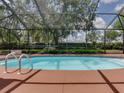 Relaxing screened-in pool area featuring a sparkling in-ground pool with clear blue water at 1610 Sanderling Ct, Brandon, FL 33511