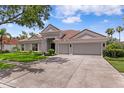 Charming single-story home with tile roof, well-manicured lawn and a three-car garage at 17807 Arbor Greene Dr, Tampa, FL 33647