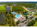Aerial view showcases community amenities: pool, tennis courts, playground, and green spaces at 18508 Merseyside Loop, Land O Lakes, FL 34638