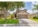 Inviting two-story home with a two-car garage, mature trees, and well-maintained lawn at 18508 Merseyside Loop, Land O Lakes, FL 34638