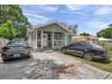 Charming single-story home with a welcoming front porch and well-maintained front yard with driveway and multiple cars at 2108 E Linebaugh Ave, Tampa, FL 33612