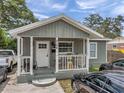 Inviting front porch with chairs and a table, perfect for relaxing and enjoying the outdoors at 2108 E Linebaugh Ave, Tampa, FL 33612