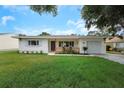 Inviting single-Gathering home with a cozy front porch, neat landscaping, and an attached garage, perfect for families at 245 Grove Cir N, Dunedin, FL 34698