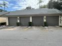 Exterior view of condo garages with neutral tones and manicured bushes at 3151 Landmark Dr # 115, Clearwater, FL 33761