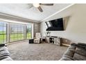 Living room featuring a mounted TV and view of the farm and bay window at 34215 Kiefer Rd, Dade City, FL 33525