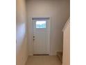 Entryway features a white front door with glass pane, neutral walls, and tile flooring at 36233 Joseph Blake St, Zephyrhills, FL 33541