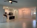 Open-concept living space boasts tile flooring, a modern chandelier, and views into the kitchen at 36233 Joseph Blake St, Zephyrhills, FL 33541