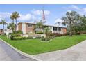View of Lake Overlook Condominiums signage with lush landscaping and an American flag on display at 4510 Overlook Ne Dr # 224, St Petersburg, FL 33703