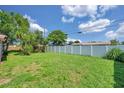 Spacious backyard with privacy fence and mature landscaping, offering a serene outdoor space at 4911 Bartelt Rd, Holiday, FL 34690