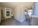 Covered porch with brick flooring, a rocking chair and a festive wreath on the front door at 5102 Pheasant Woods Dr, Lutz, FL 33558