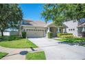 Inviting home featuring a well-manicured lawn, 2-car garage and traditional architectural details at 5102 Pheasant Woods Dr, Lutz, FL 33558