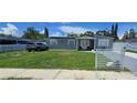 Charming gray home featuring a well-manicured lawn and white picket fence at 5106 Town N Country Blvd, Tampa, FL 33615
