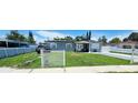 Charming gray home featuring a well-manicured lawn and white picket fence at 5106 Town N Country Blvd, Tampa, FL 33615