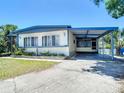 Inviting single-Gathering home featuring a covered parking area and a neatly manicured front lawn at 5806 Portsmouth Dr, Tampa, FL 33615